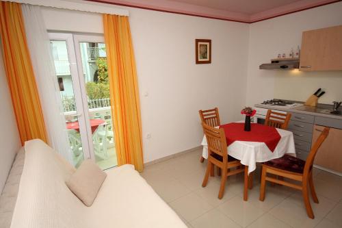 eine Küche und ein Esszimmer mit Tisch und Stühlen in der Unterkunft Apartment Slano 3183c in Slano