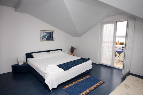 - une chambre avec un lit blanc et une grande fenêtre dans l'établissement Apartments with a parking space Slano, Dubrovnik - 3183, à Slano