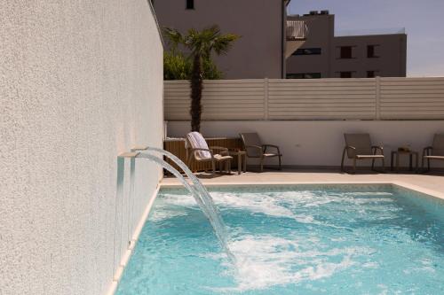 a pool with a water fountain on the side of a building at Villa Miki in Podstrana