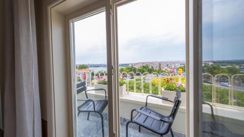 a balcony with two chairs and windows with a view at The Gift Hotel in Istanbul
