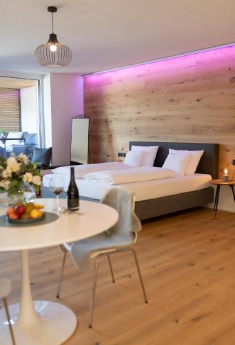 a bedroom with a bed and a table and chairs at geislerAPPARTMENTS in Gramatneusiedl