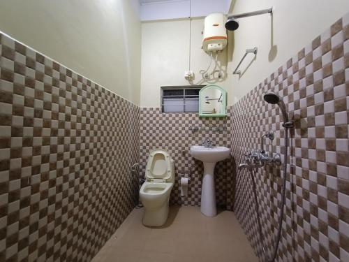 a small bathroom with a toilet and a sink at Odyssey Stays Jowai - West Jaintia Hills in Jowai