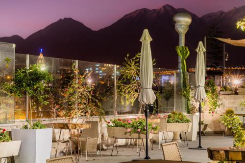 a patio with tables and umbrellas and flowers at Palla Boutique Hotel in Arequipa