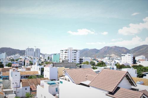 a city with buildings and mountains in the background at Thien Truong Hotel in Nha Trang