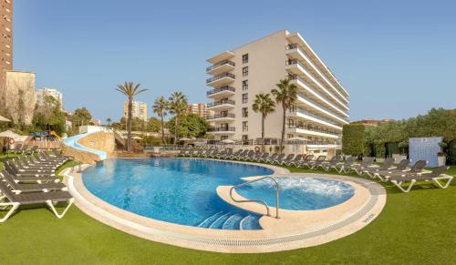 a swimming pool with lounge chairs and a building at Hotel RH Corona del Mar 4* Sup in Benidorm