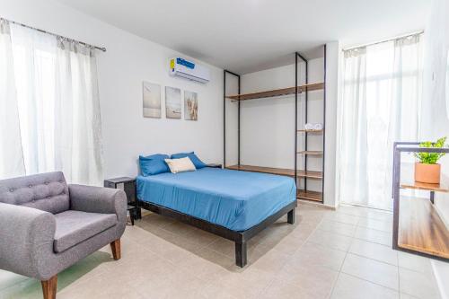 a bedroom with a blue bed and a chair at Casa Familiar Sian Kaan in Caucel