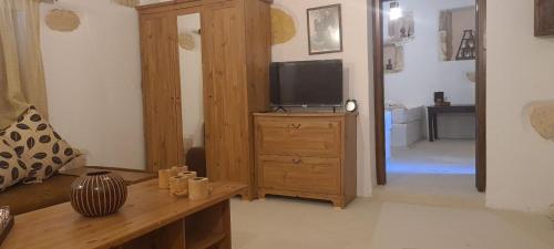 a living room with a television on a wooden dresser at Cretan House Antonis in Kamilari