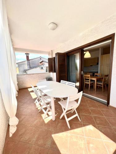 a white table and chairs on a balcony at Villa Ortensie Apartments in Funtana