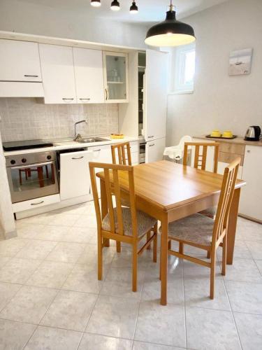 a kitchen with a wooden dining room table and chairs at Villa Ortensie Apartments in Funtana