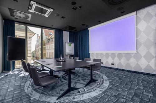 a meeting room with a table and a projection screen at ibis Styles Szczecin Stare Miasto in Szczecin