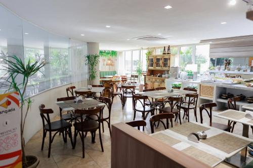 a dining room with tables and chairs in a restaurant at Atlantic Palace Apart-Hotel in Aquiraz