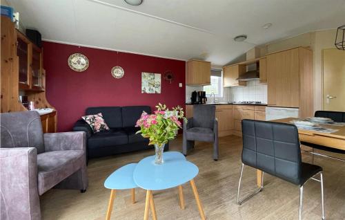 ein Wohnzimmer mit einem Sofa und einem Tisch mit Blumen darauf in der Unterkunft 2 Bedroom Amazing Home In Tzummarum in Tzummarum