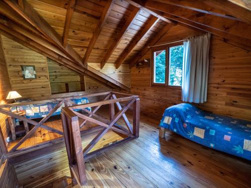 um quarto com 2 beliches num chalé de madeira em Hosteria Pichi Rincon em Villa La Angostura