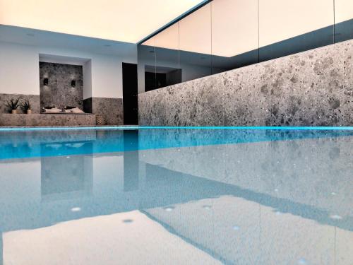 an empty swimming pool in a house with a concrete wall at Hotel Villa Select in De Panne