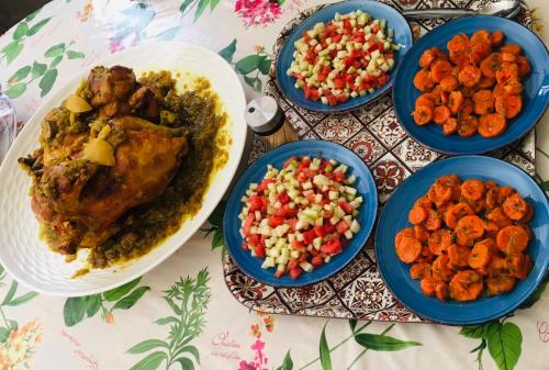 a table topped with plates of food and bowls of vegetables at Riad Nasma Souihla in Marrakech