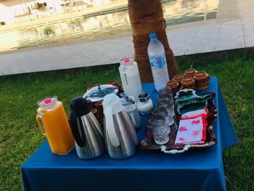 a blue table with drinks and cups and bottles on it at Riad Nasma Souihla in Marrakech