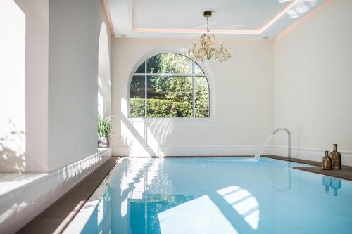 a swimming pool in a white room with a window at Classic Hotel Am Stetteneck in Ortisei
