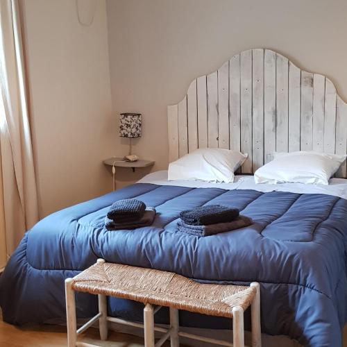 une chambre avec un grand lit avec une couette bleue dans l'établissement Gîte du caveau, à Marcorignan