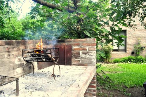 a grill with a fire in a yard at Los Olivos Loft in Rosario