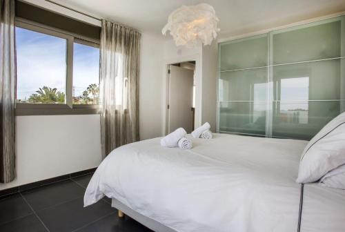 ein Schlafzimmer mit einem weißen Bett und einem großen Fenster in der Unterkunft Villa Vallesa Calpe in Calpe