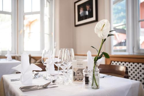 a white flower in a vase on a table at Classic Hotel Am Stetteneck in Ortisei
