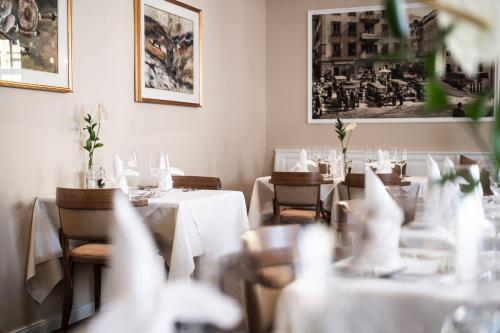 a restaurant with tables and chairs with white tablecloths at Classic Hotel Am Stetteneck in Ortisei