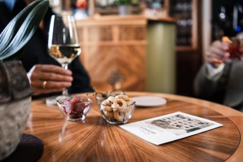 a person sitting at a table with a glass of wine at Classic Hotel Am Stetteneck in Ortisei