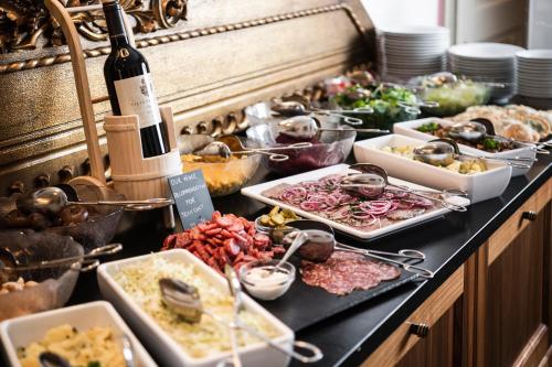 a buffet with a lot of food and a bottle of wine at Classic Hotel Am Stetteneck in Ortisei