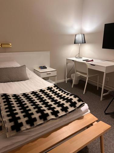 a bedroom with a bed and a desk and a computer at Hotell Garvaren in Ljungby