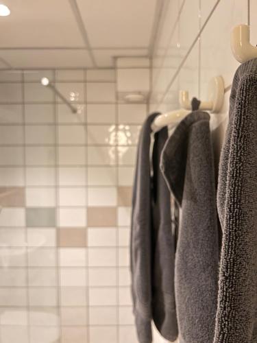 a group of towels hanging on a rack in a bathroom at Hotell Garvaren in Ljungby