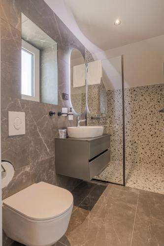 a bathroom with a toilet and a sink and a mirror at Villa Miki in Podstrana