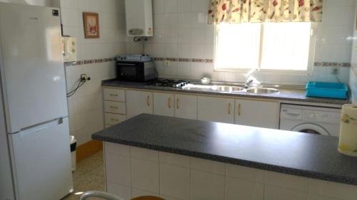 eine Küche mit einem weißen Kühlschrank und einer Spüle in der Unterkunft Casa Manoli in El Palmar