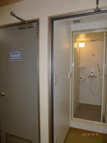 a bathroom with a shower and a mirror in it at Hotel Diamond in Osaka