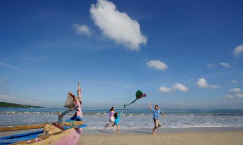 un grupo de personas en la playa volando cometas en InterContinental Bali Resort, an IHG Hotel en Jimbaran