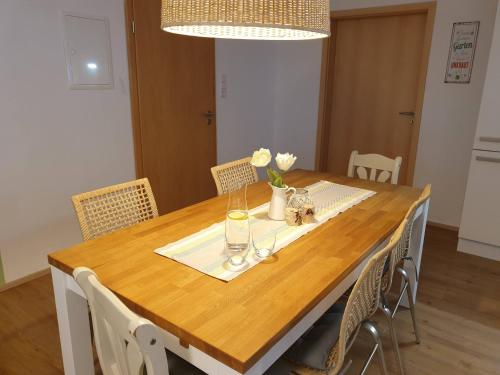 a dining room table with chairs and a wooden table with flowers at FeWo Frühling in der Villa Waldrand mit großem Garten in Bad Wünnenberg