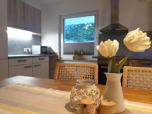 a kitchen with a table with a vase and flowers at FeWo Frühling in der Villa Waldrand mit großem Garten in Bad Wünnenberg