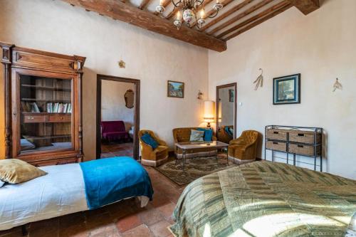 une chambre avec un lit et un salon dans l'établissement Appartement spacieux à Ferrières-les-Verreries avec jardin privé, à Ferrières-les-Verreries