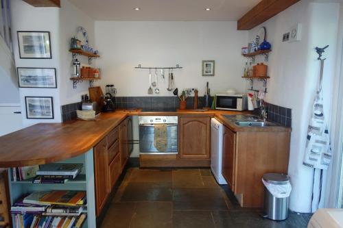 a kitchen with wooden cabinets and a counter top at St Michaels Coach House in Crediton