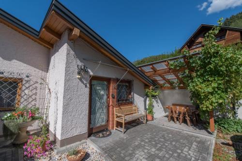 a patio of a house with a bench and a table at Ferienwohnungen Angermaier in Flattach