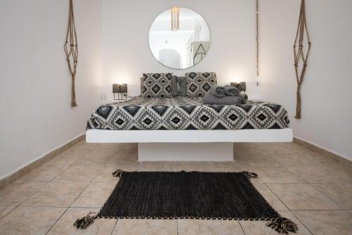 a bedroom with a bed with a mirror and a rug at Eris Studios in Adamas