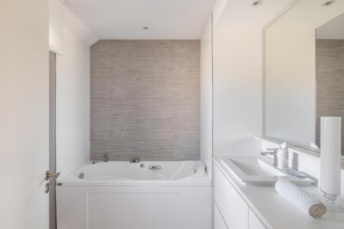 biała łazienka z wanną i umywalką w obiekcie FENUA - Quartier de Rothéneuf w Saint-Malo