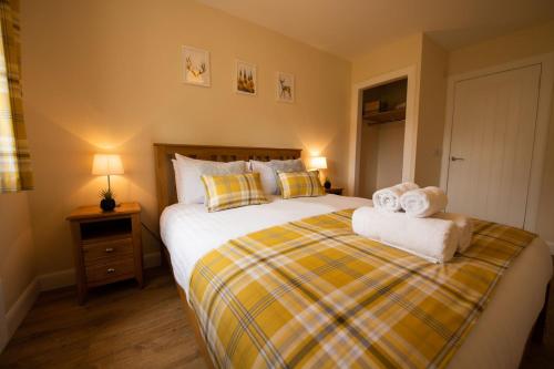 a bedroom with a large bed with towels on it at Stobhan Apartment in Fort William