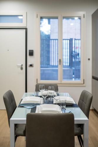 a white table with chairs and wine glasses on it at Fragole Suite in Bologna