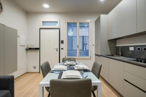 uma sala de jantar com uma mesa e cadeiras numa cozinha em Fragole Suite em Bolonha
