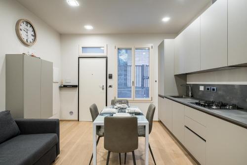 uma cozinha e sala de estar com mesa e cadeiras em Fragole Suite em Bolonha