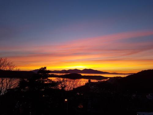 a sunset over a lake with mountains in the background at Ardura Apartment No 1 in Oban