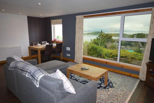 a living room with a couch and a table and a window at Ardura Apartment No 1 in Oban