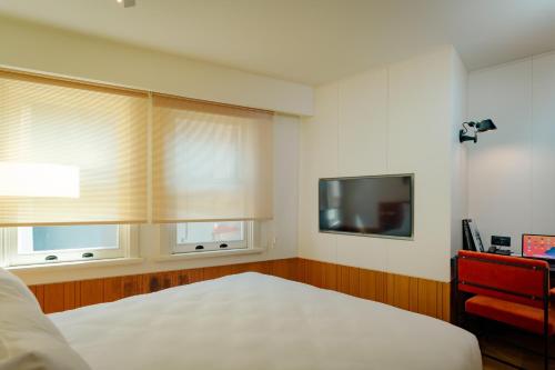 a bedroom with two windows and a bed and a television at The Gift Hotel in Istanbul