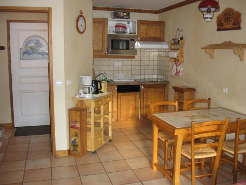 - une cuisine avec une table, des placards en bois, une table et des chaises dans l'établissement Appartement 2 pièces, 4 personnes, 3 étoiles, exposé Sud, Valloire - FR-1-263-128, à Valloire