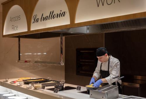 a chef preparing food in a restaurant kitchen at Hotel RH Ifach in Calpe
